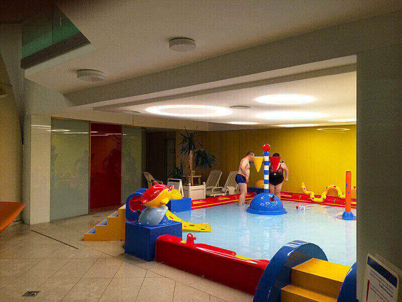 Átvilágítós feszített fólia álmennyezet LED karikákkal. Barrisol feszített fóliás design világítás Kolping Hotel SPA gyermekmedencéje felett. A fénykarikákat ledes lámpák biztosítják.